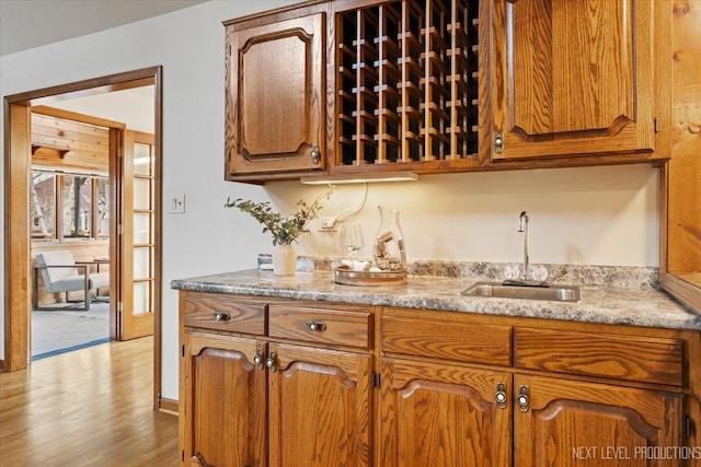 kitchen featuring brown cabinets, a sink, and light wood finished floors