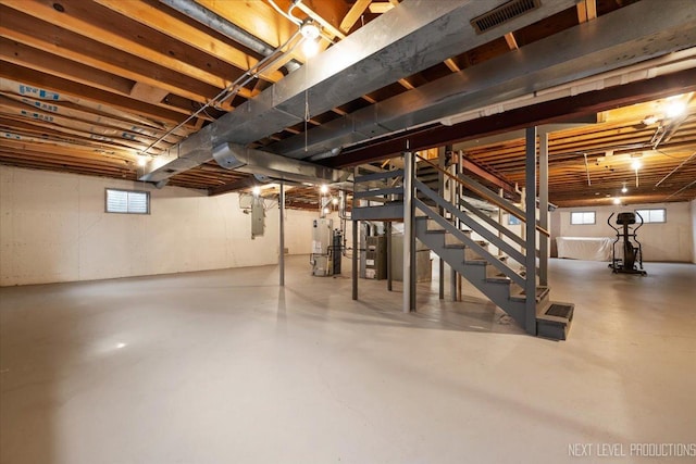 below grade area featuring water heater, visible vents, and stairs