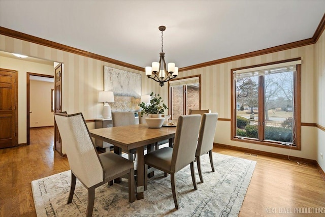 dining space with ornamental molding, light wood-style flooring, and wallpapered walls