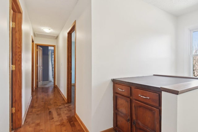 hallway with light hardwood / wood-style flooring and a textured ceiling