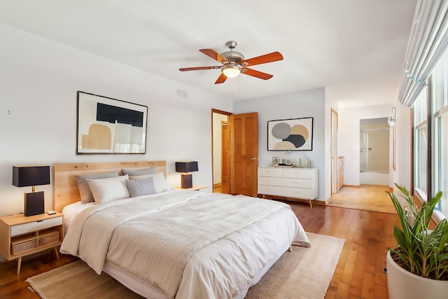 bedroom featuring hardwood / wood-style flooring, ensuite bath, and ceiling fan