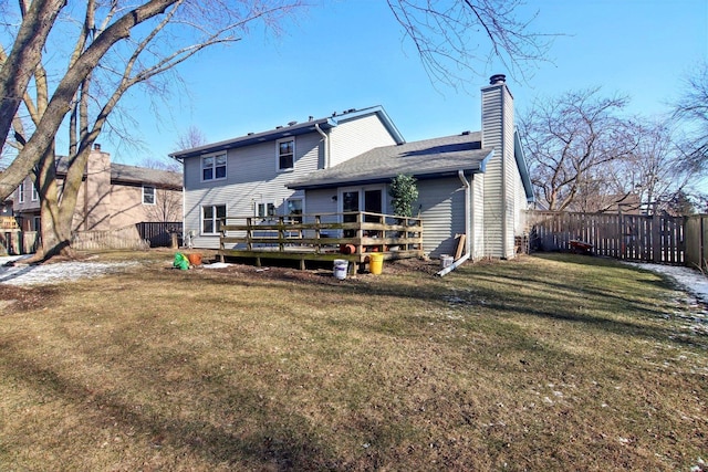 rear view of property with a wooden deck and a lawn