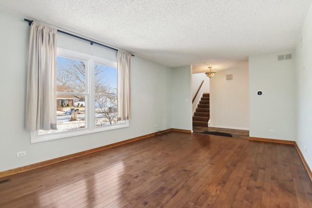 spare room with dark hardwood / wood-style flooring and a textured ceiling