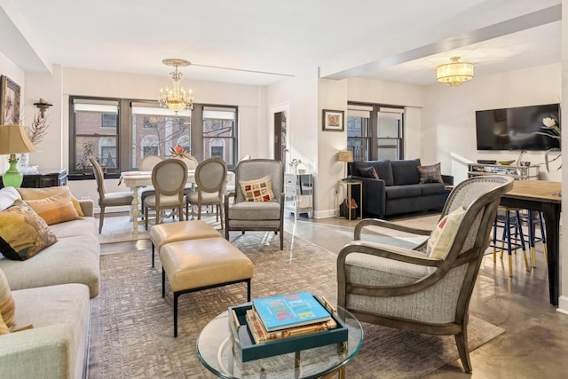 living room featuring a chandelier and concrete floors