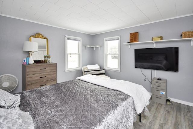 bedroom with ornamental molding and hardwood / wood-style floors