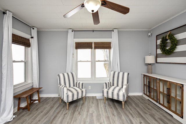 sitting room with crown molding, plenty of natural light, and wood-type flooring