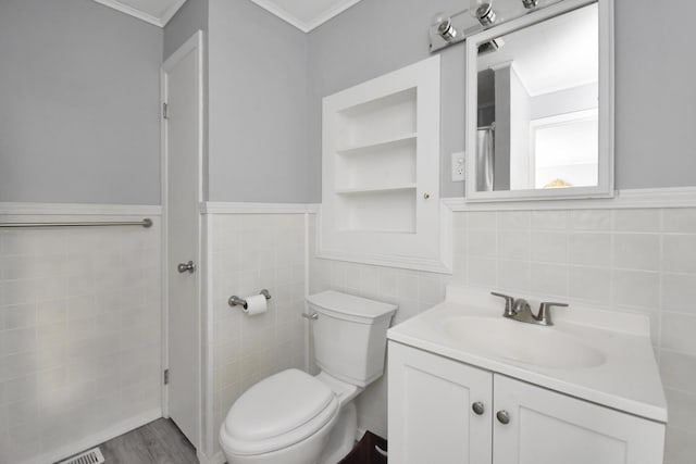 bathroom with tile walls, hardwood / wood-style floors, vanity, ornamental molding, and toilet