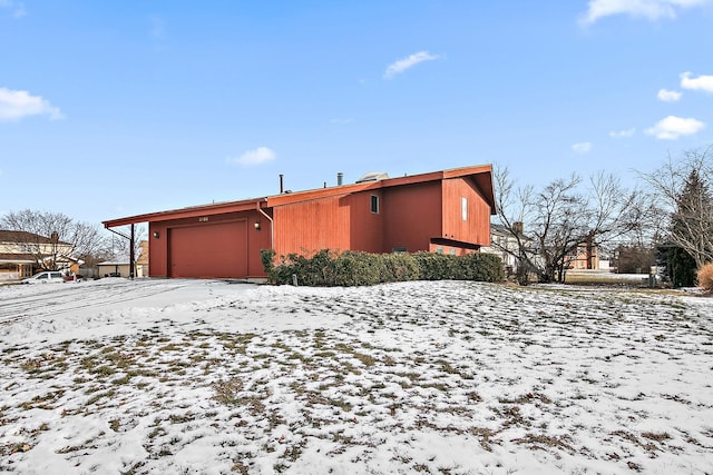 snow covered property featuring a garage