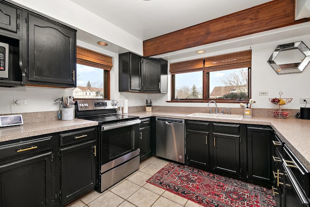 kitchen with sink, light tile patterned floors, and stainless steel appliances