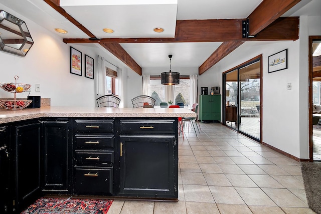 kitchen featuring light tile patterned flooring, beam ceiling, kitchen peninsula, and hanging light fixtures