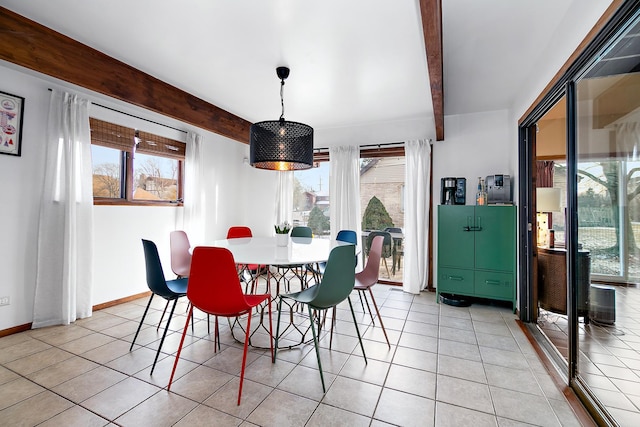 tiled dining area featuring beam ceiling