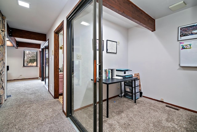 hall featuring beam ceiling and carpet floors