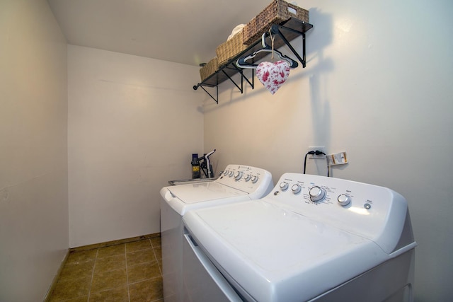 laundry room with washing machine and dryer and dark tile patterned floors