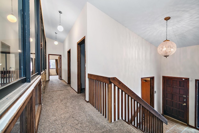 hallway featuring light carpet and high vaulted ceiling