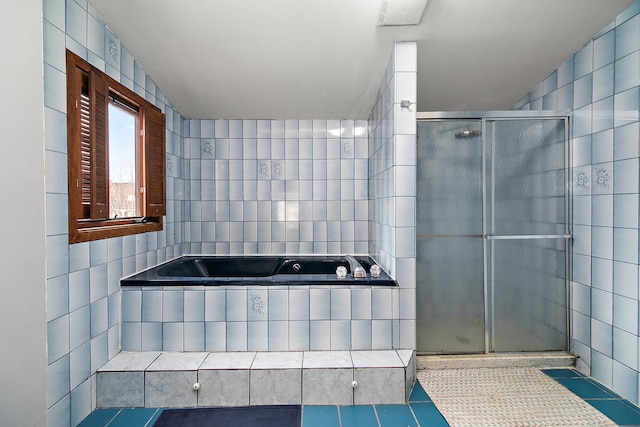 bathroom with tile patterned flooring, plus walk in shower, and tile walls