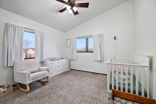 carpeted bedroom featuring multiple windows, lofted ceiling, a nursery area, and ceiling fan