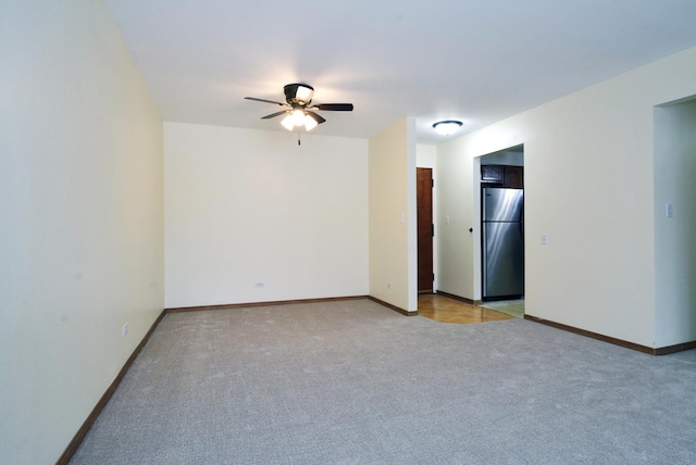 empty room featuring ceiling fan and light carpet