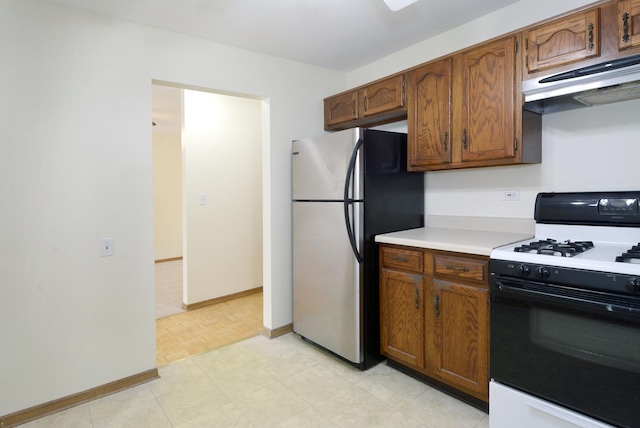 kitchen with gas range oven and stainless steel refrigerator