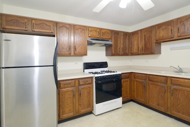 kitchen with sink, range with gas stovetop, stainless steel refrigerator, and ceiling fan