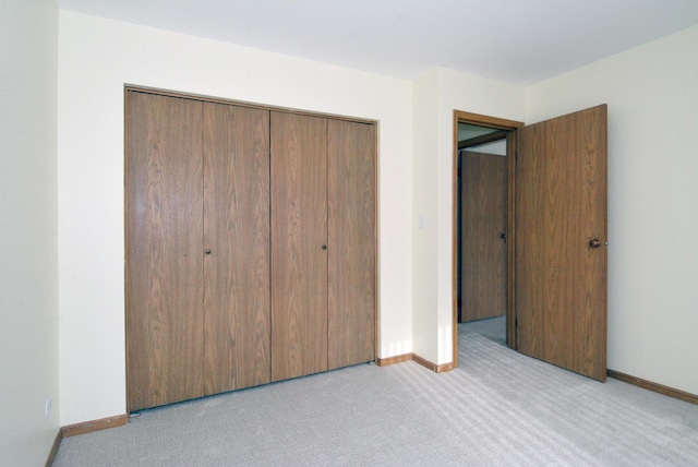 unfurnished bedroom with light carpet and a closet