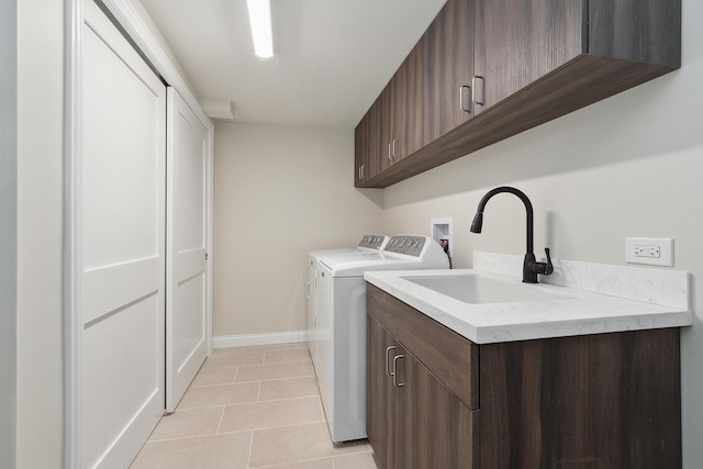 laundry area with washer and dryer, sink, cabinets, and light tile patterned flooring