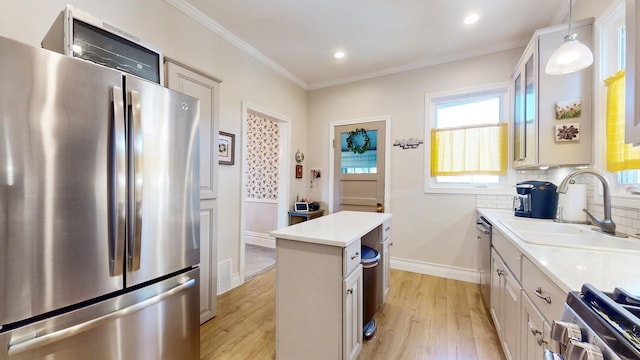 kitchen with decorative backsplash, stainless steel fridge, light wood-type flooring, and decorative light fixtures