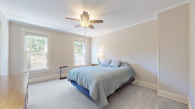 carpeted bedroom featuring crown molding and ceiling fan