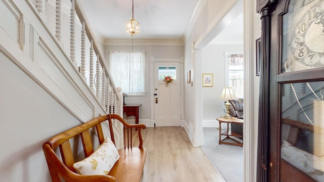 entrance foyer featuring crown molding and light hardwood / wood-style flooring