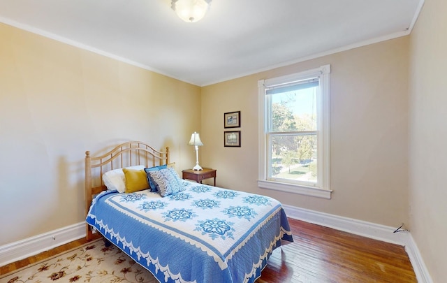 bedroom with hardwood / wood-style flooring and crown molding