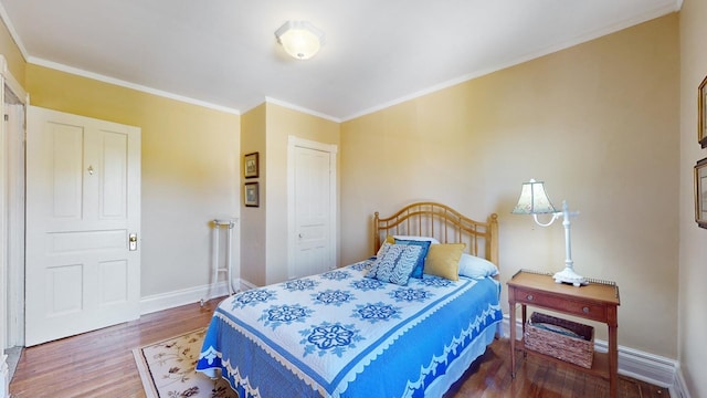 bedroom with wood-type flooring and ornamental molding