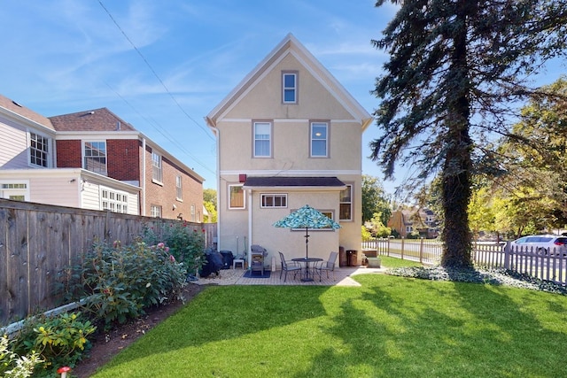 rear view of house featuring a lawn and a patio