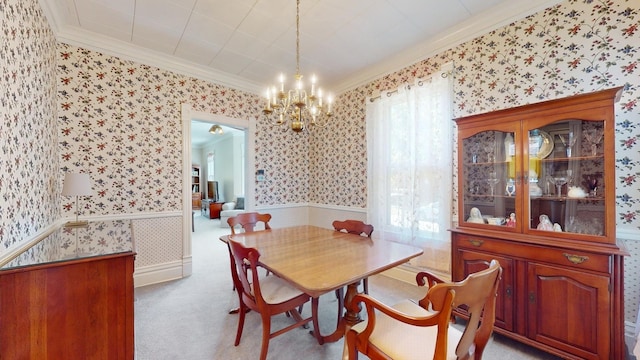 dining room featuring light carpet, ornamental molding, and a chandelier