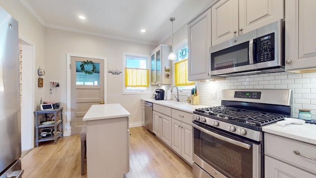 kitchen featuring sink, white cabinetry, stainless steel appliances, light hardwood / wood-style floors, and a kitchen island