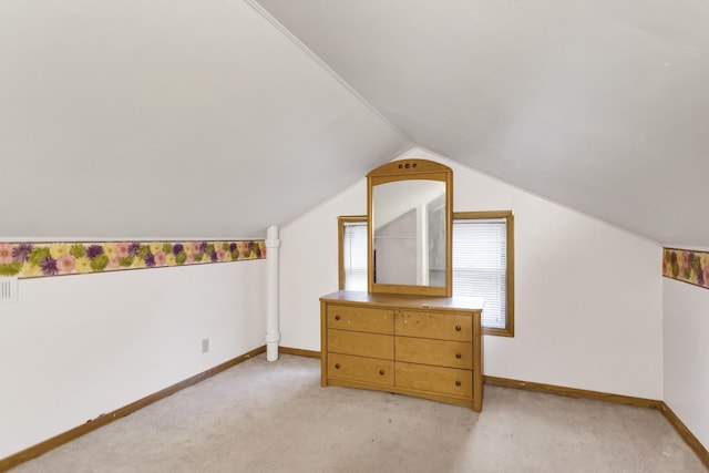 additional living space featuring lofted ceiling and light colored carpet