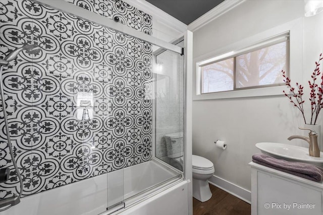 full bathroom with toilet, combined bath / shower with glass door, crown molding, wood-type flooring, and vanity