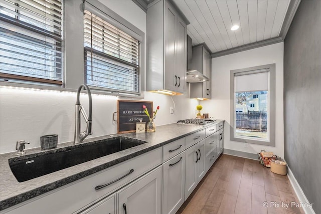 kitchen with sink, gray cabinetry, ornamental molding, dark hardwood / wood-style floors, and stainless steel gas stovetop