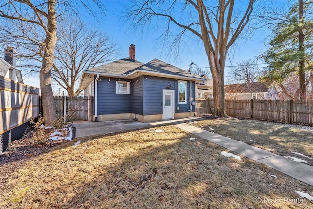 back of house with a yard and a patio