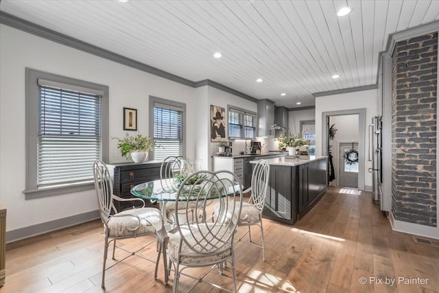 dining room with ornamental molding, light wood-type flooring, beverage cooler, and wood ceiling