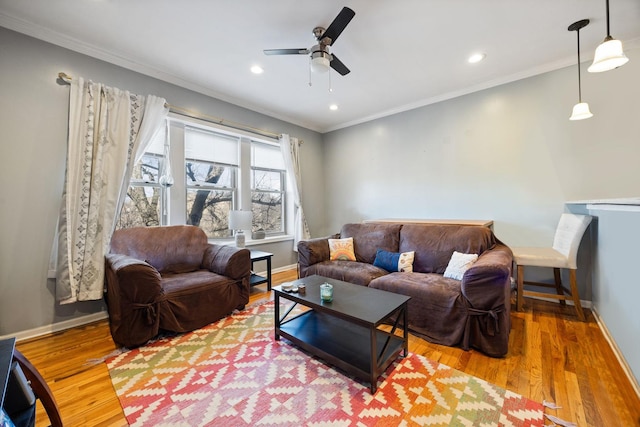 living room with hardwood / wood-style flooring, ceiling fan, and ornamental molding