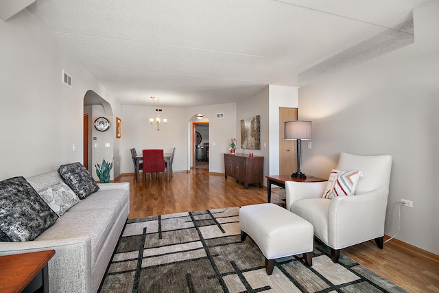 living room with wood-type flooring and a notable chandelier