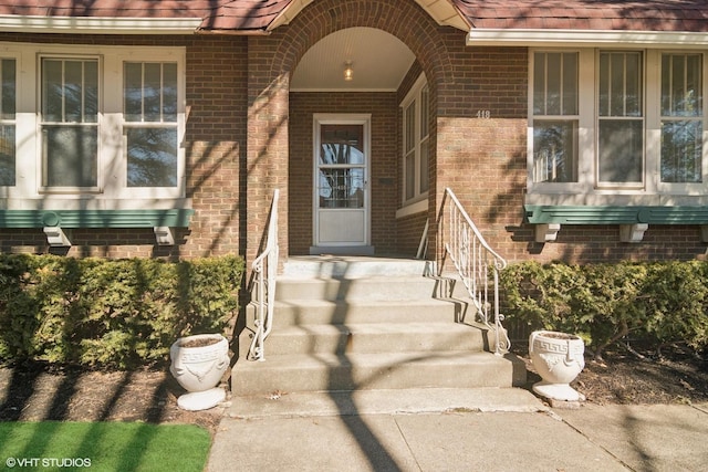 entrance to property featuring brick siding