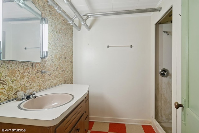 bathroom with baseboards, crown molding, vanity, and wallpapered walls