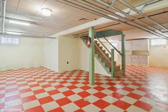 basement featuring stairs and light floors