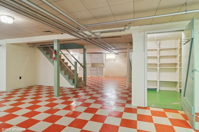 basement featuring stairway and tile patterned floors