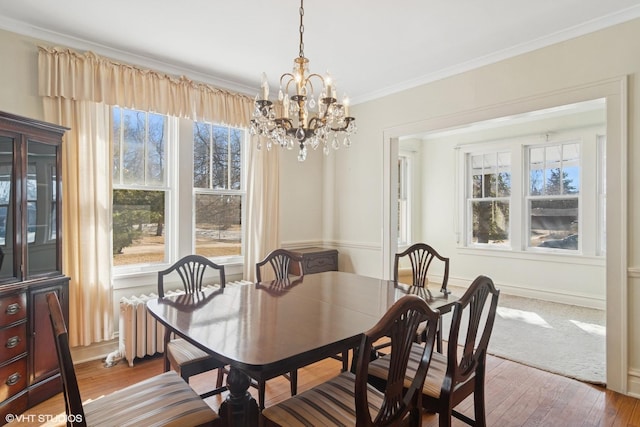 dining area with ornamental molding, plenty of natural light, hardwood / wood-style floors, and baseboards