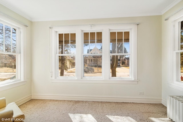 spare room featuring ornamental molding, radiator, and baseboards