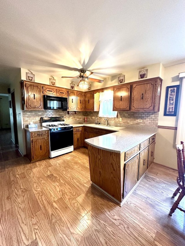 kitchen with range with gas stovetop, light hardwood / wood-style floors, and ceiling fan