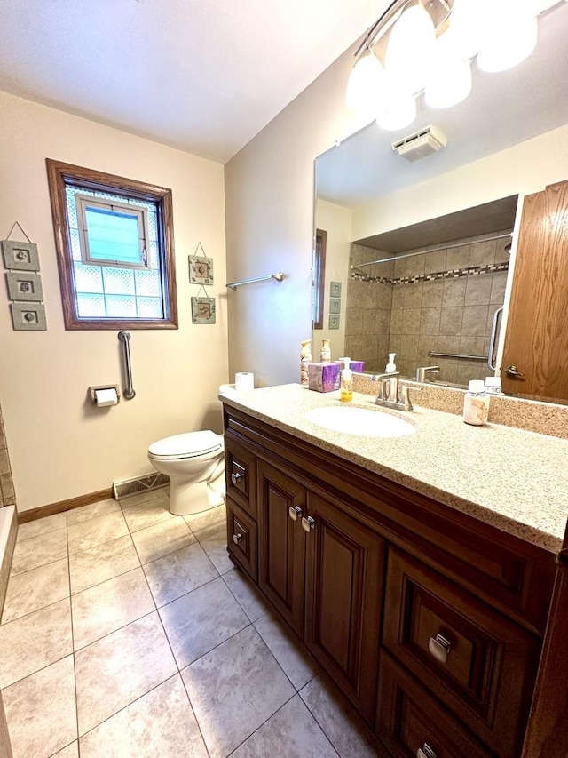 bathroom featuring vanity, tile patterned floors, toilet, and walk in shower