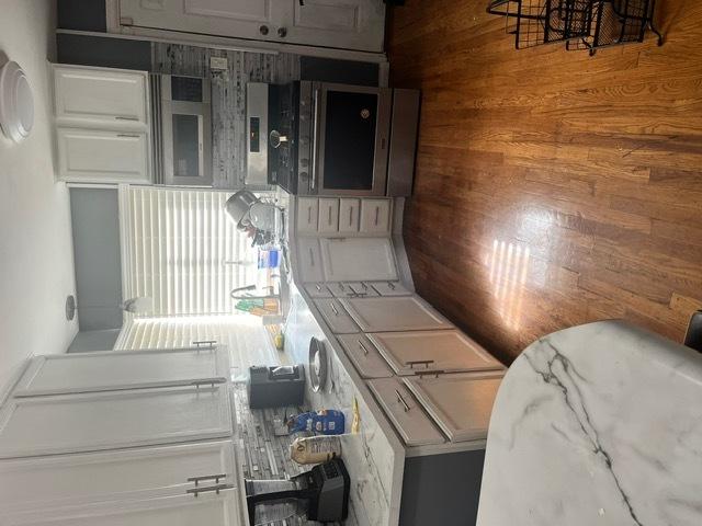 kitchen featuring wooden walls and white cabinets