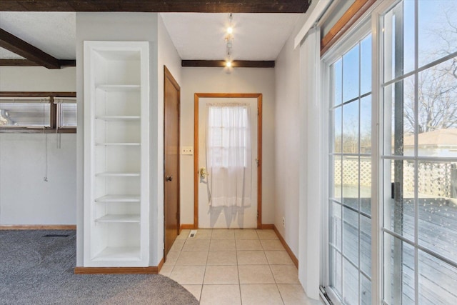 doorway to outside featuring built in shelves, beamed ceiling, and light tile patterned floors